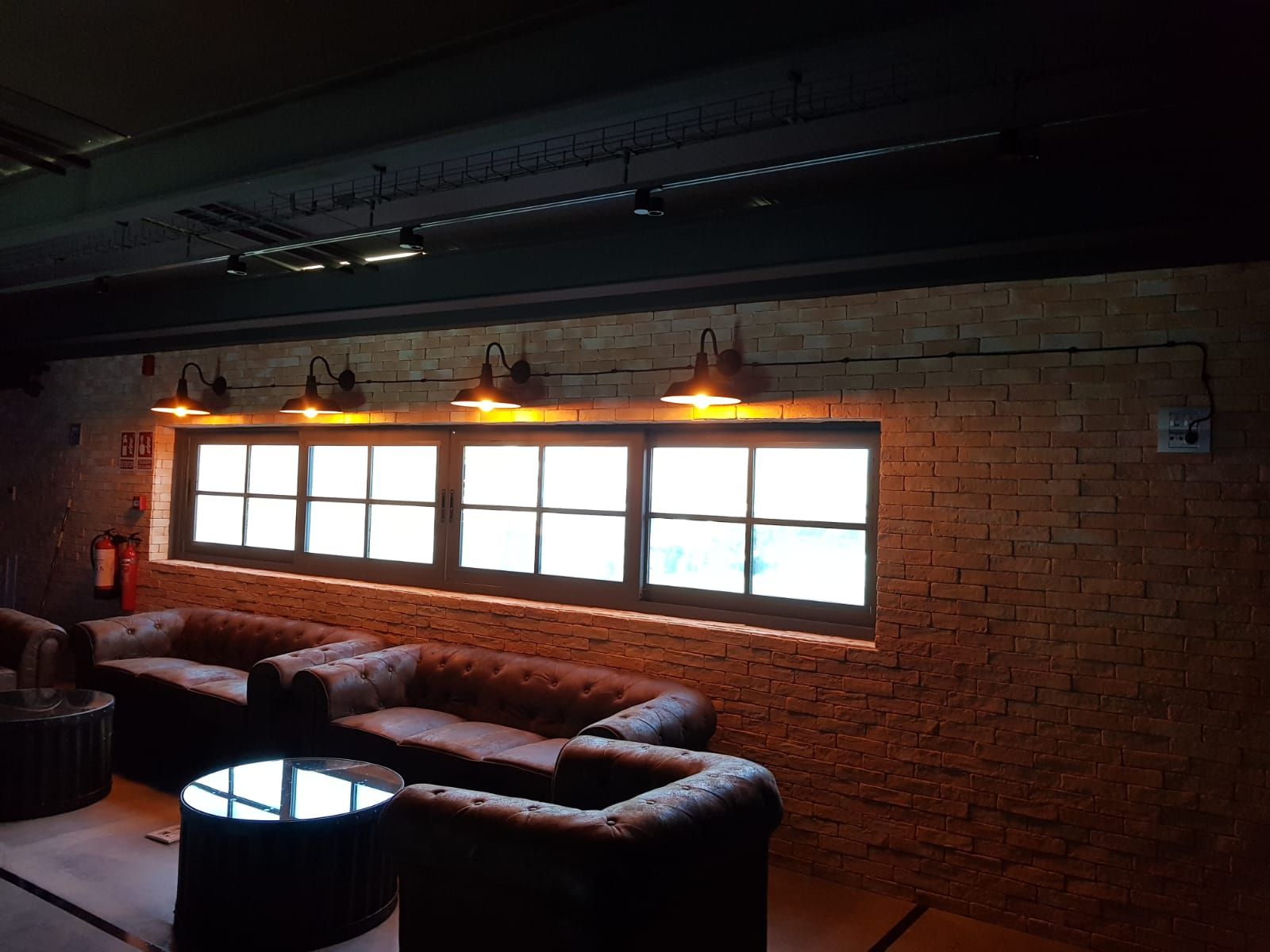 Una sala de estar con un sofá, sillas y una mesa frente a una ventana.