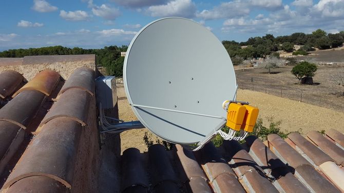 Una antena parabólica está montada en el techo de un edificio