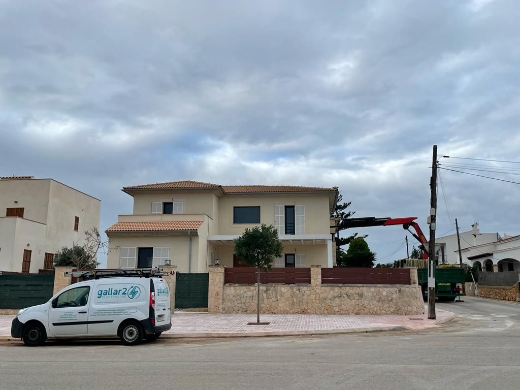 Una camioneta blanca está estacionada frente a una casa