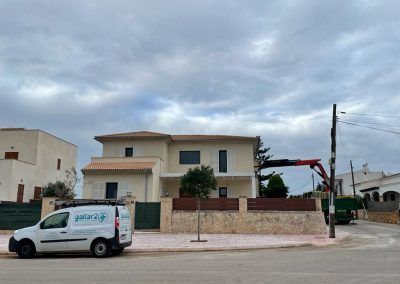Una camioneta blanca está estacionada frente a una casa grande.
