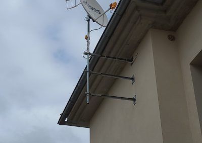 Una antena parabólica está montada en el lateral de un edificio.