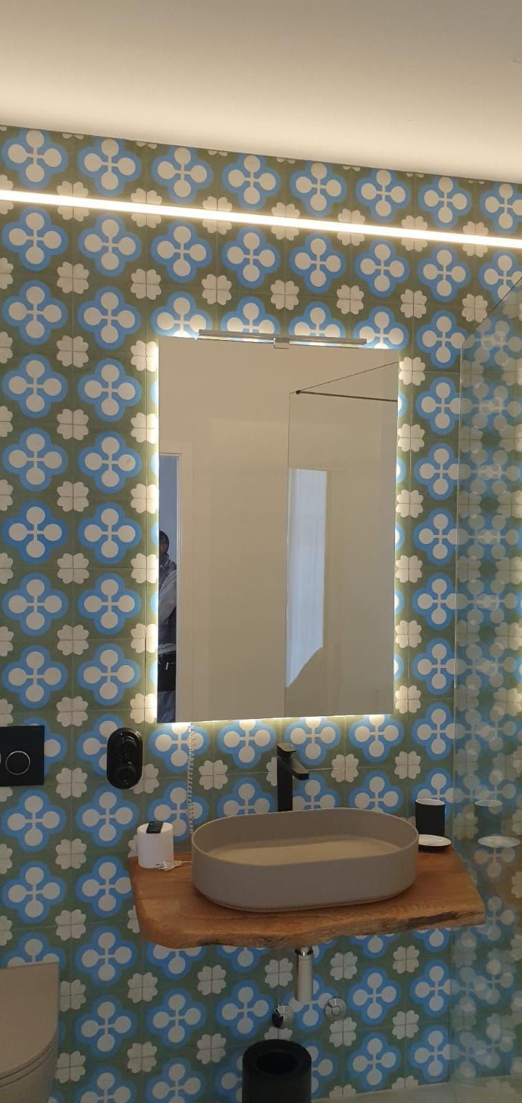 Un baño con un lavabo y un espejo con luces.