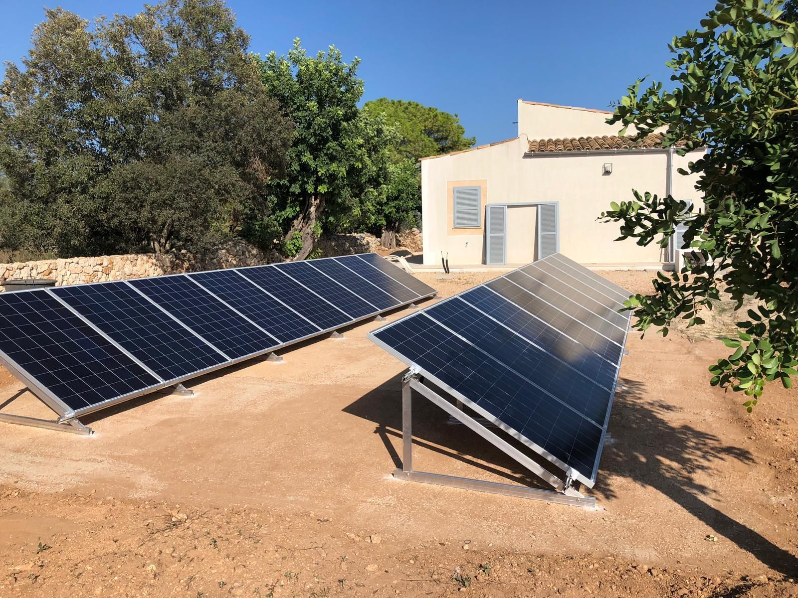 Una fila de paneles solares frente a una casa