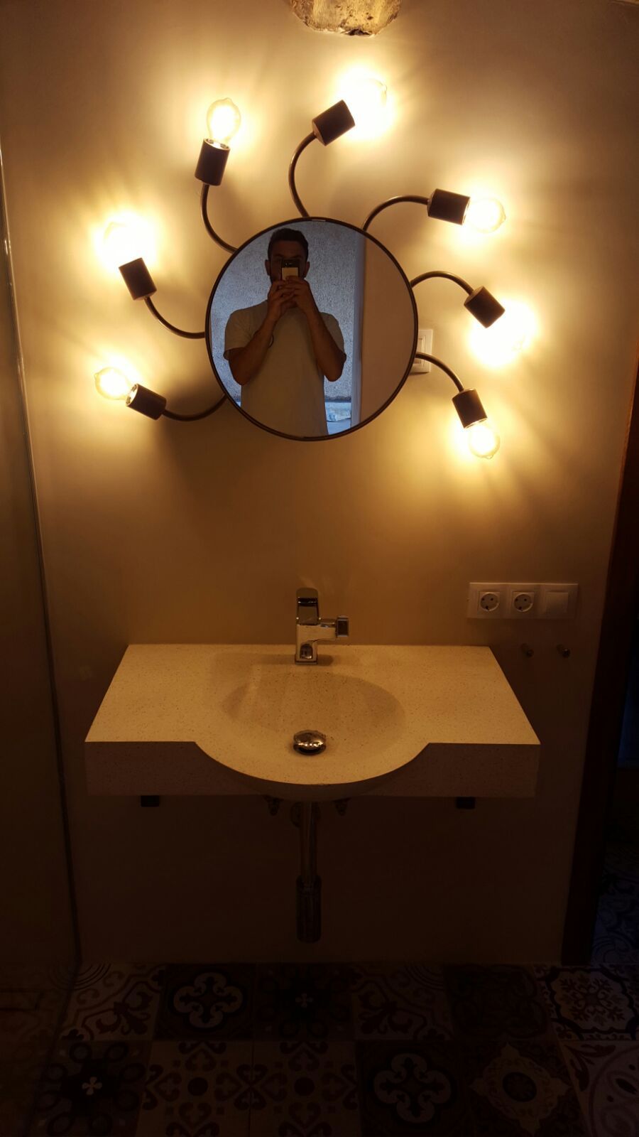 Un hombre se toma una foto en el espejo del baño.