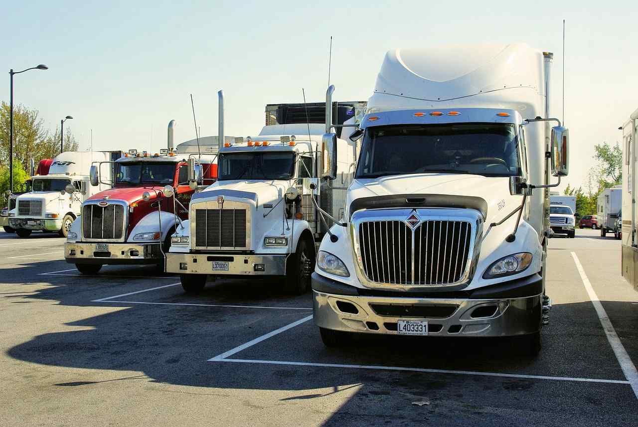 Una fila de semirremolques están estacionados en un estacionamiento.