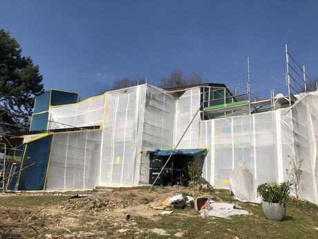 Un grand bâtiment est recouvert de plastique et d'échafaudages.