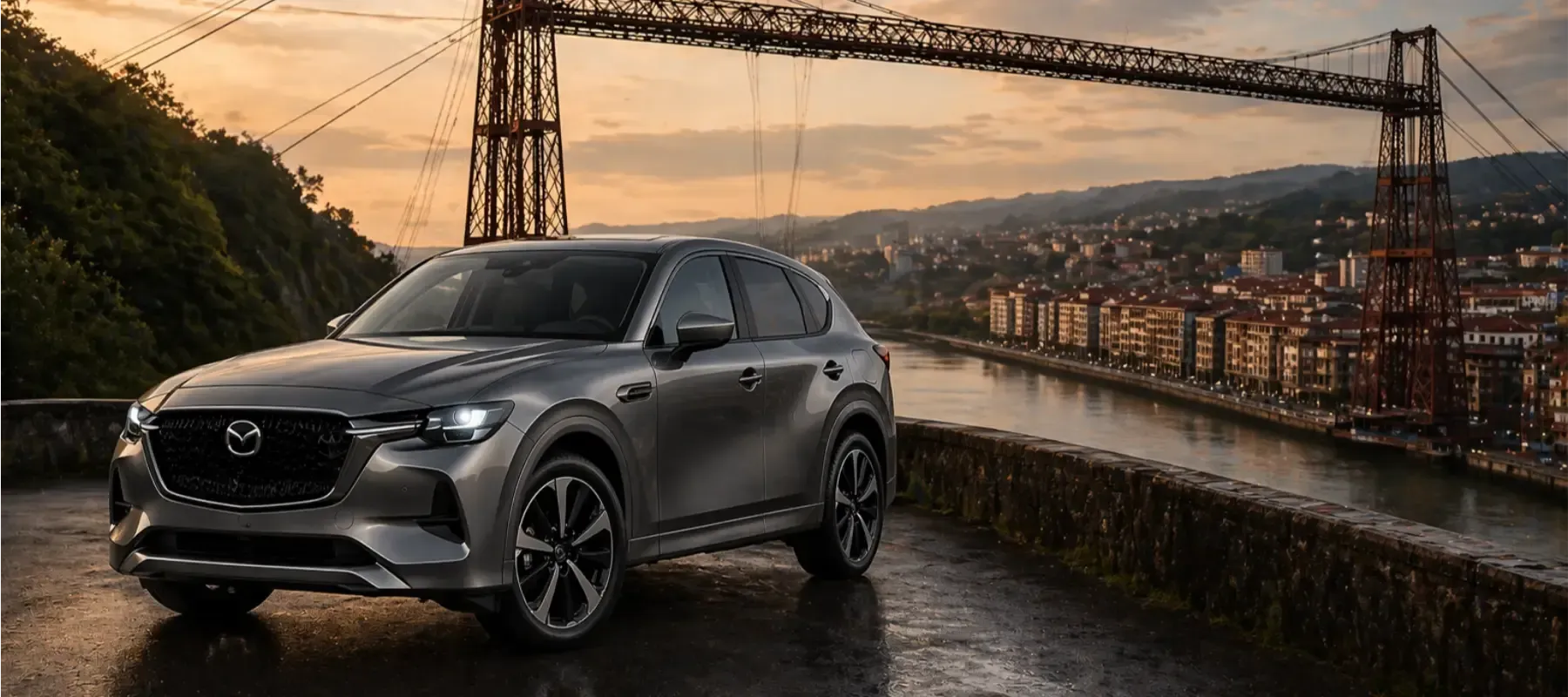 SUV gris en una carretera mojada al atardecer, con un puente y el perfil de la ciudad al fondo.
