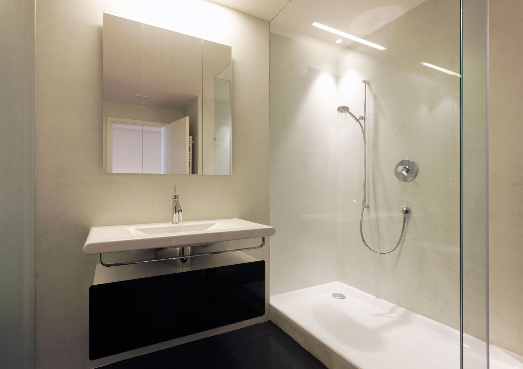 Ein Badezimmer mit Waschbecken und ebenerdiger Dusche