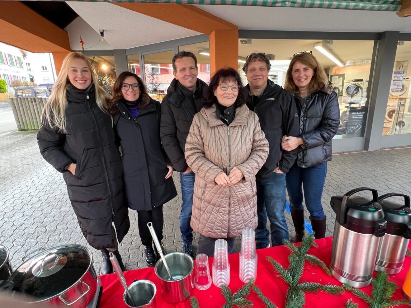 Eine Gruppe von Menschen posiert für ein Foto vor einem Tisch