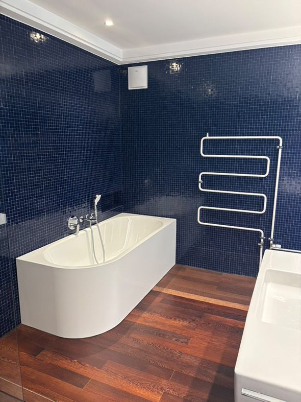 Ein Badezimmer mit Badewanne, Waschbecken und Handtuchhalter.