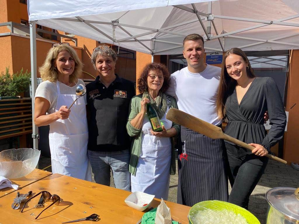 Eine Gruppe von Menschen posiert für ein Foto vor einem Zelt