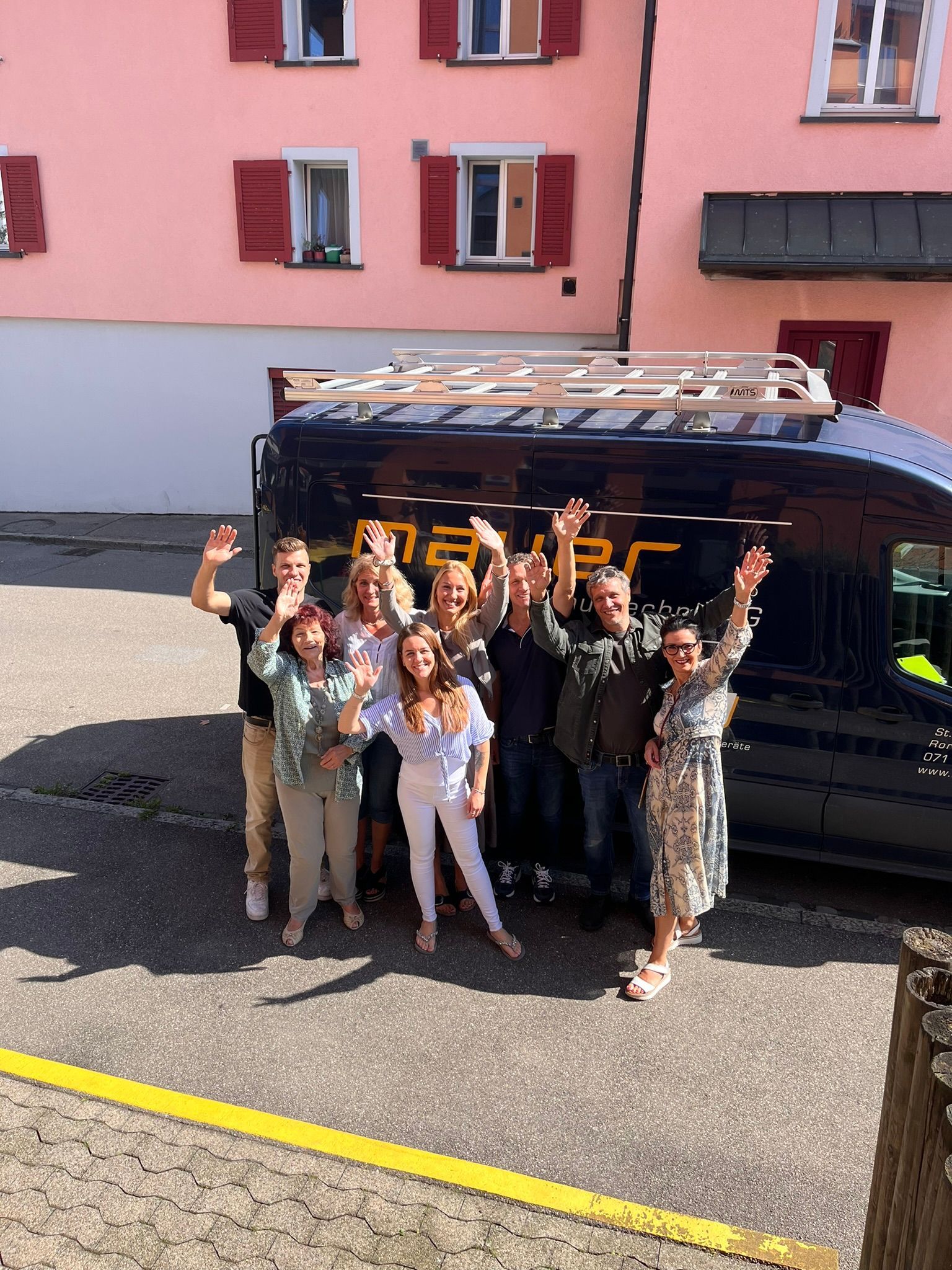 Eine Gruppe von Menschen posiert für ein Foto vor einem Lieferwagen mit der Aufschrift „Naf“