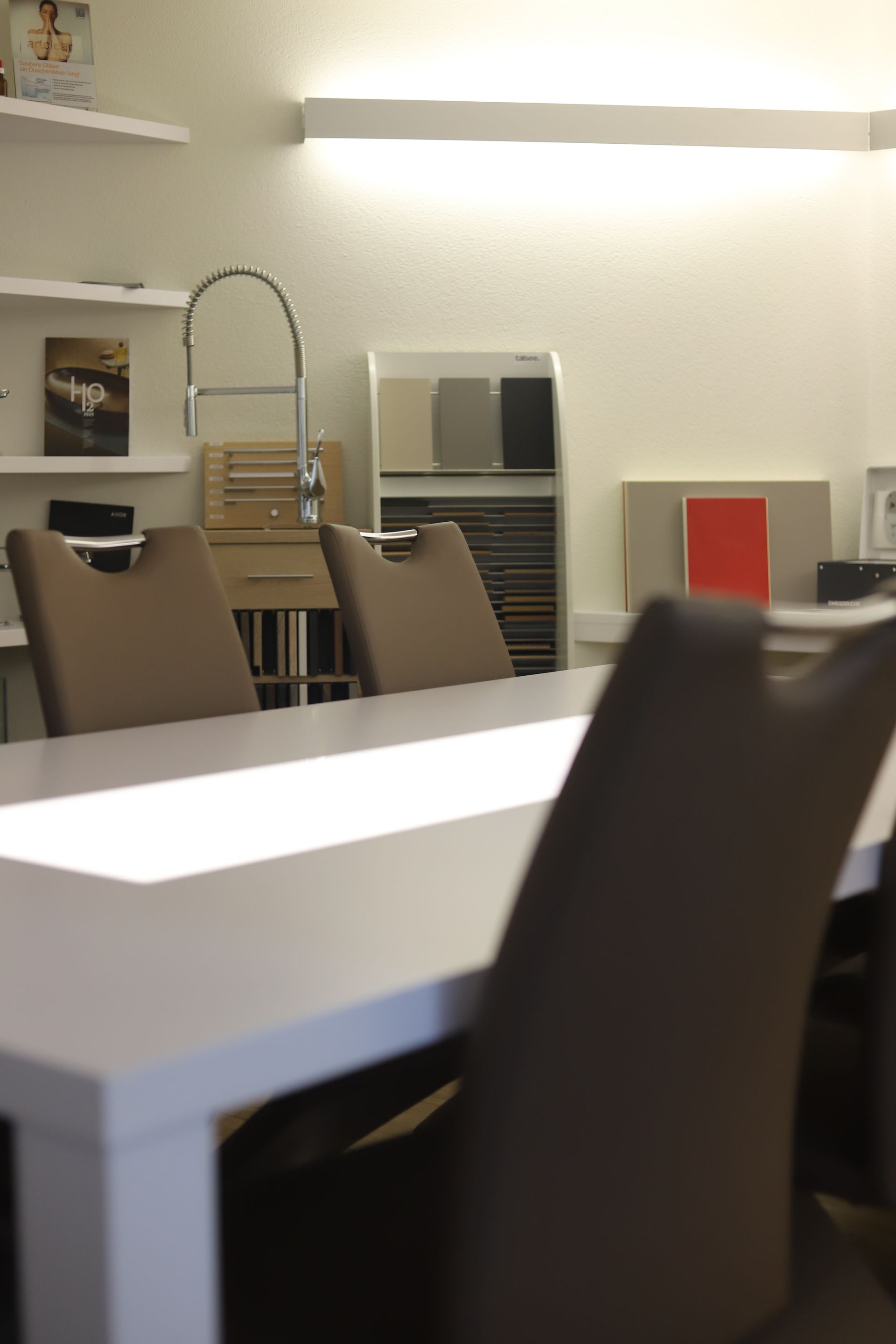 Ein weißer Tisch mit braunen Stühlen in einem Zimmer