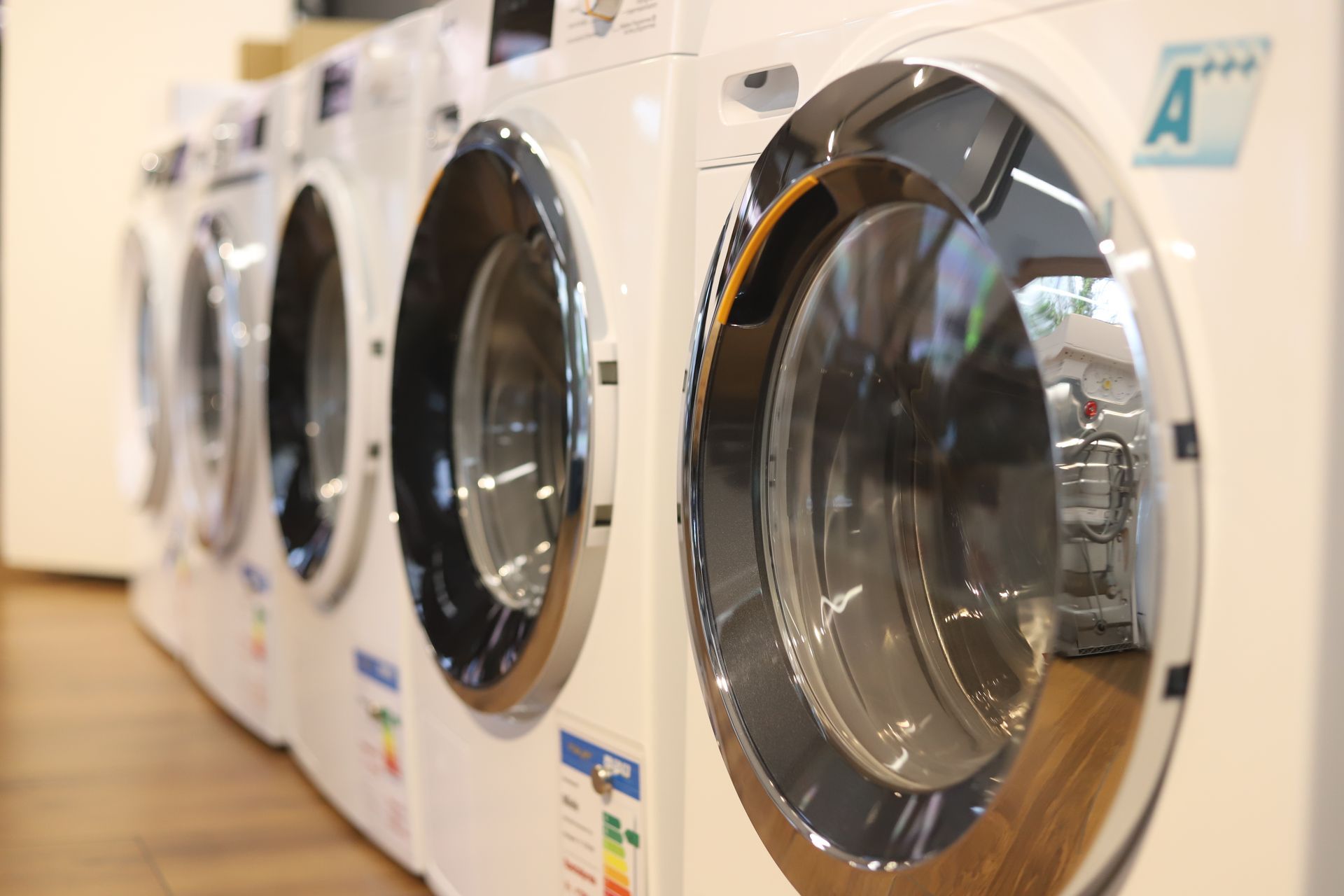 Eine Reihe von Waschmaschinen stehen nebeneinander und auf einer steht der Buchstabe a