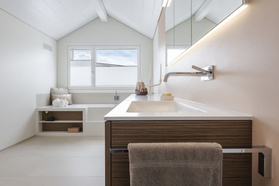 Ein Badezimmer mit Waschbecken, Spiegel und Fenster