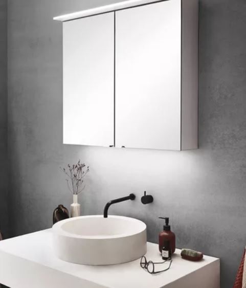 Ein Badezimmer mit einem Waschbecken und einem Spiegel darüber