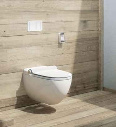 Eine weiße Toilette hängt an einer Holzwand in einem Badezimmer.