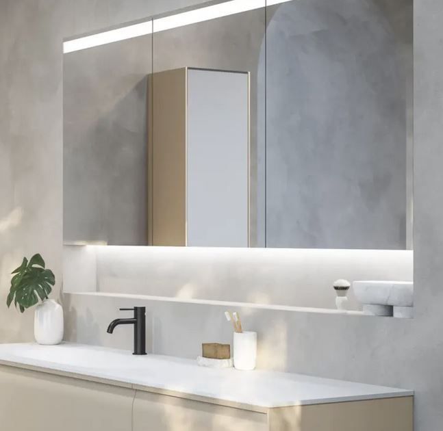 Ein Badezimmer mit Waschbecken, Spiegel und Schrank.