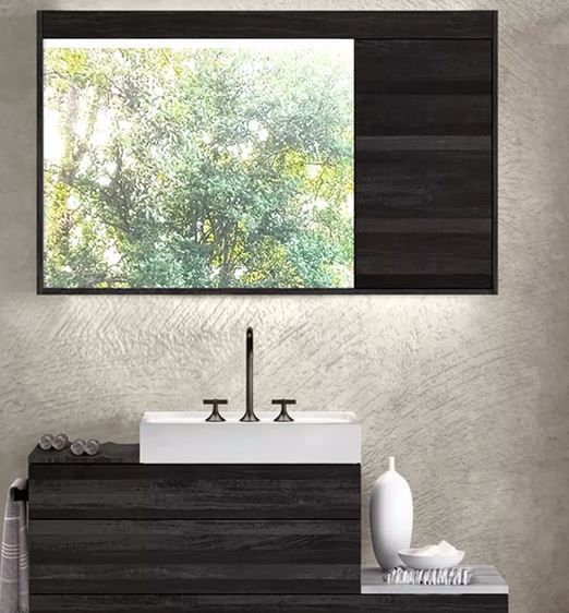 Ein Badezimmer mit Waschbecken, Spiegel und Schränken