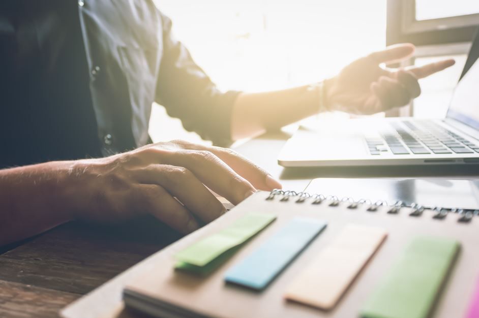 Una persona trabajando en un escritorio con una computadora portátil