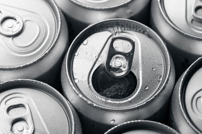Varias latas de refresco están apiladas una encima de otra