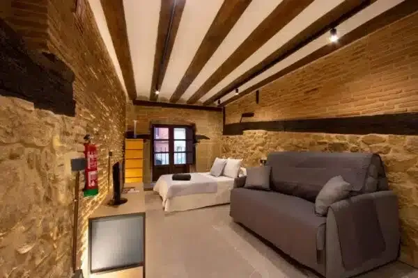 Una habitación acogedora con paredes de piedra vista, vigas de madera