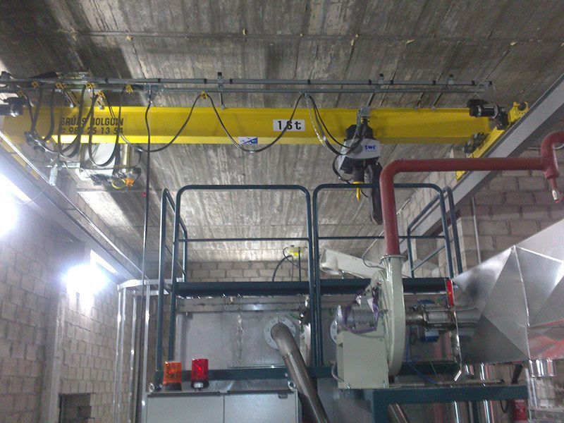 Una grúa amarilla cuelga del techo de un edificio.