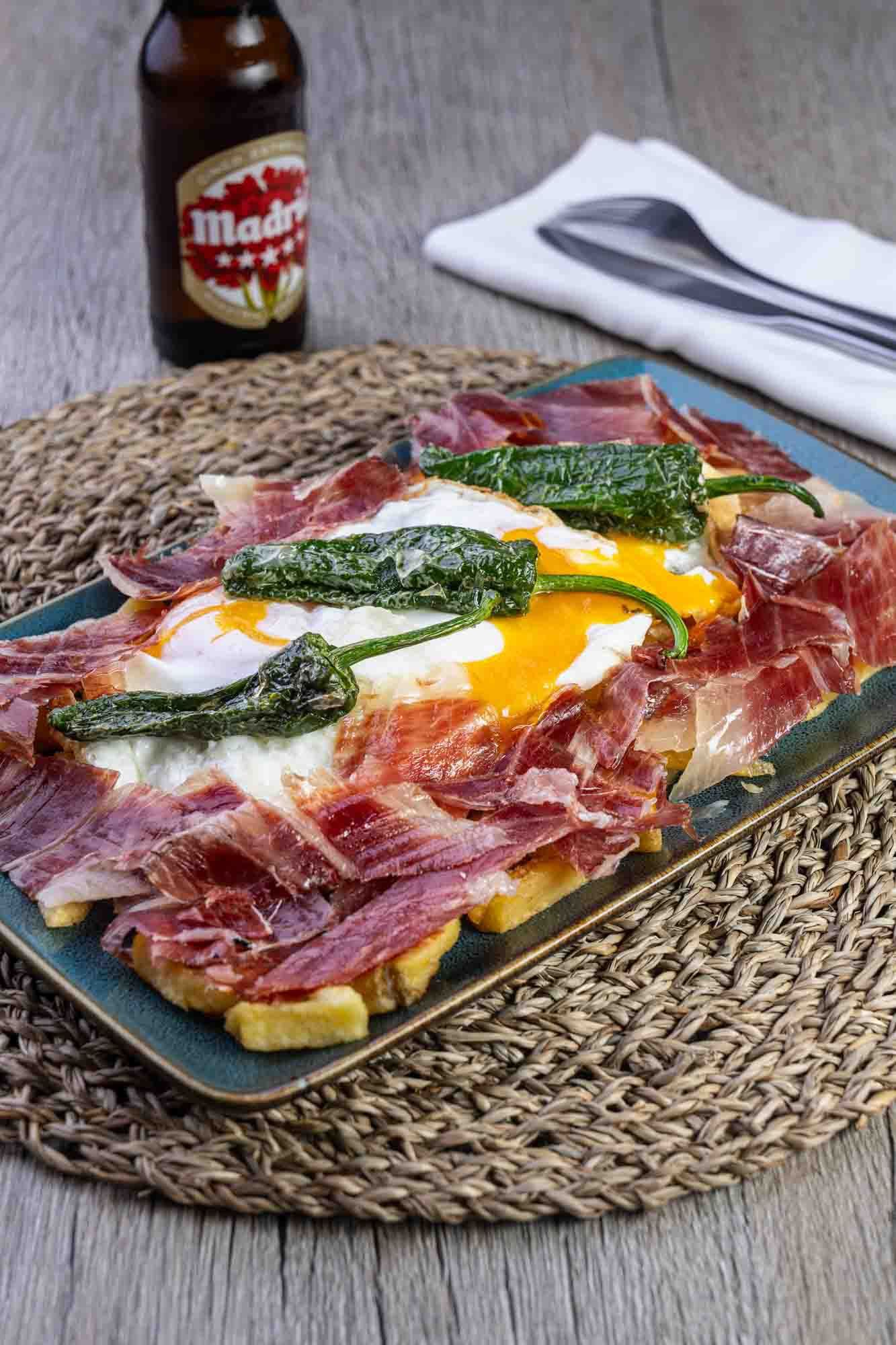 Un plato de comida con una botella de cerveza al fondo.