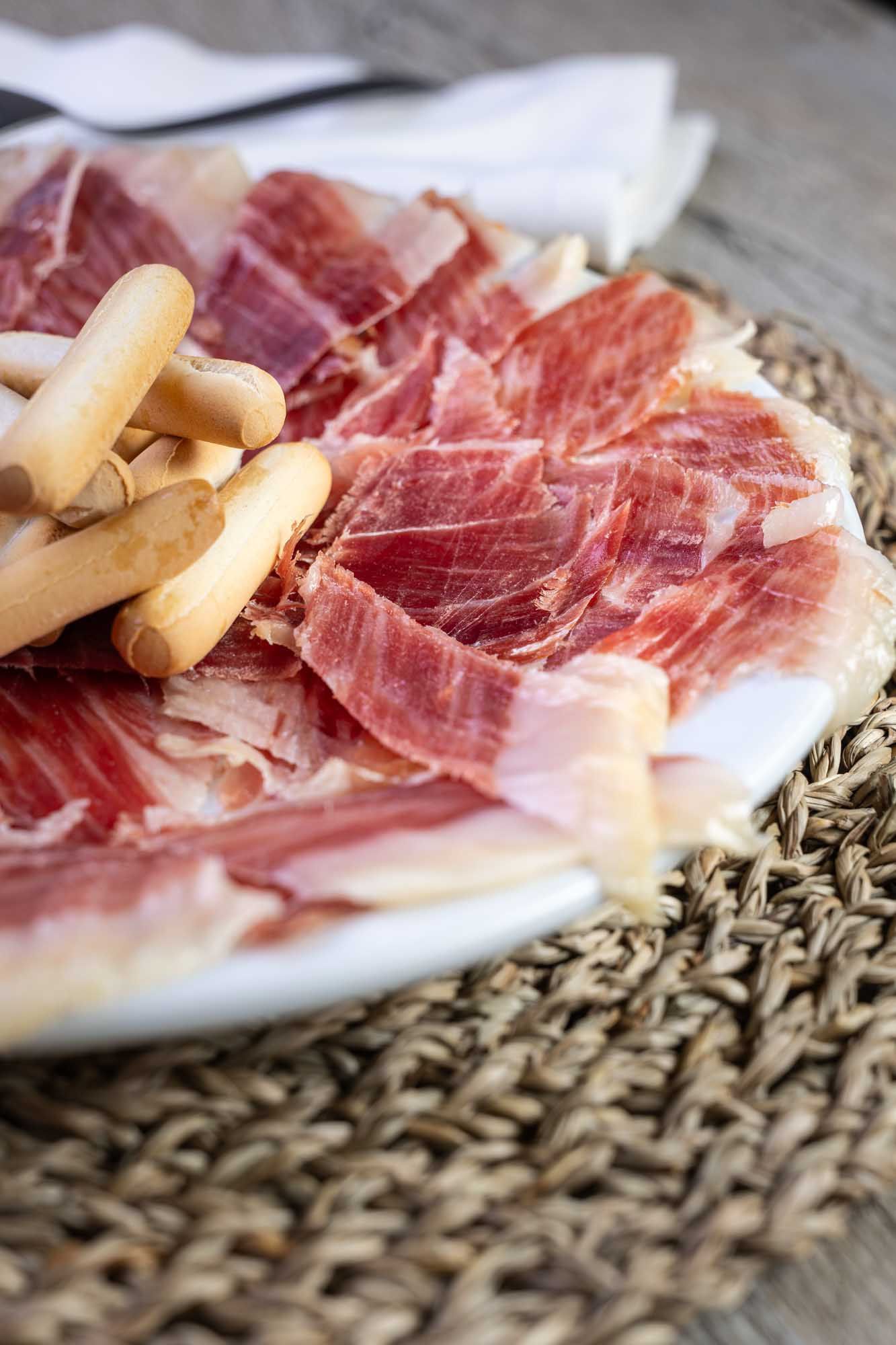 Un plato de jamón y galletas en una mesa.