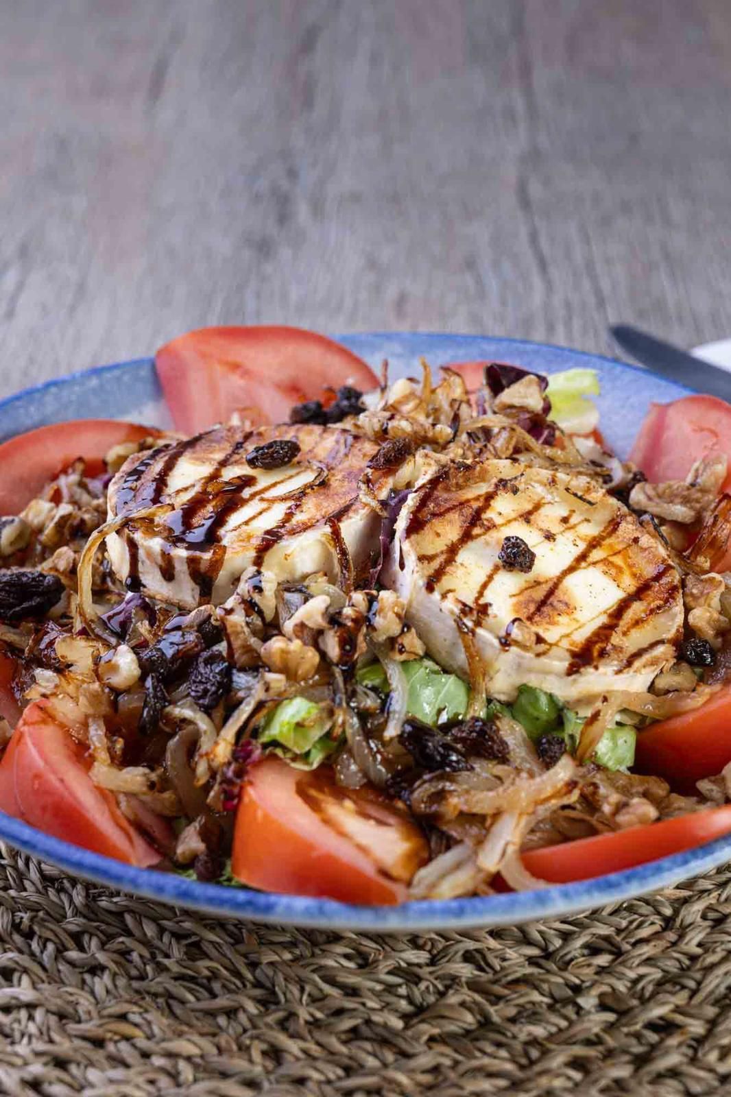 Un primer plano de un plato de comida con tomates y queso sobre una mesa.
