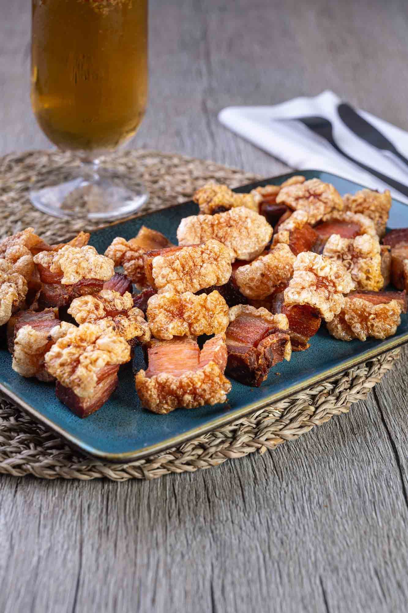 Un plato de comida con un vaso de cerveza en una mesa.