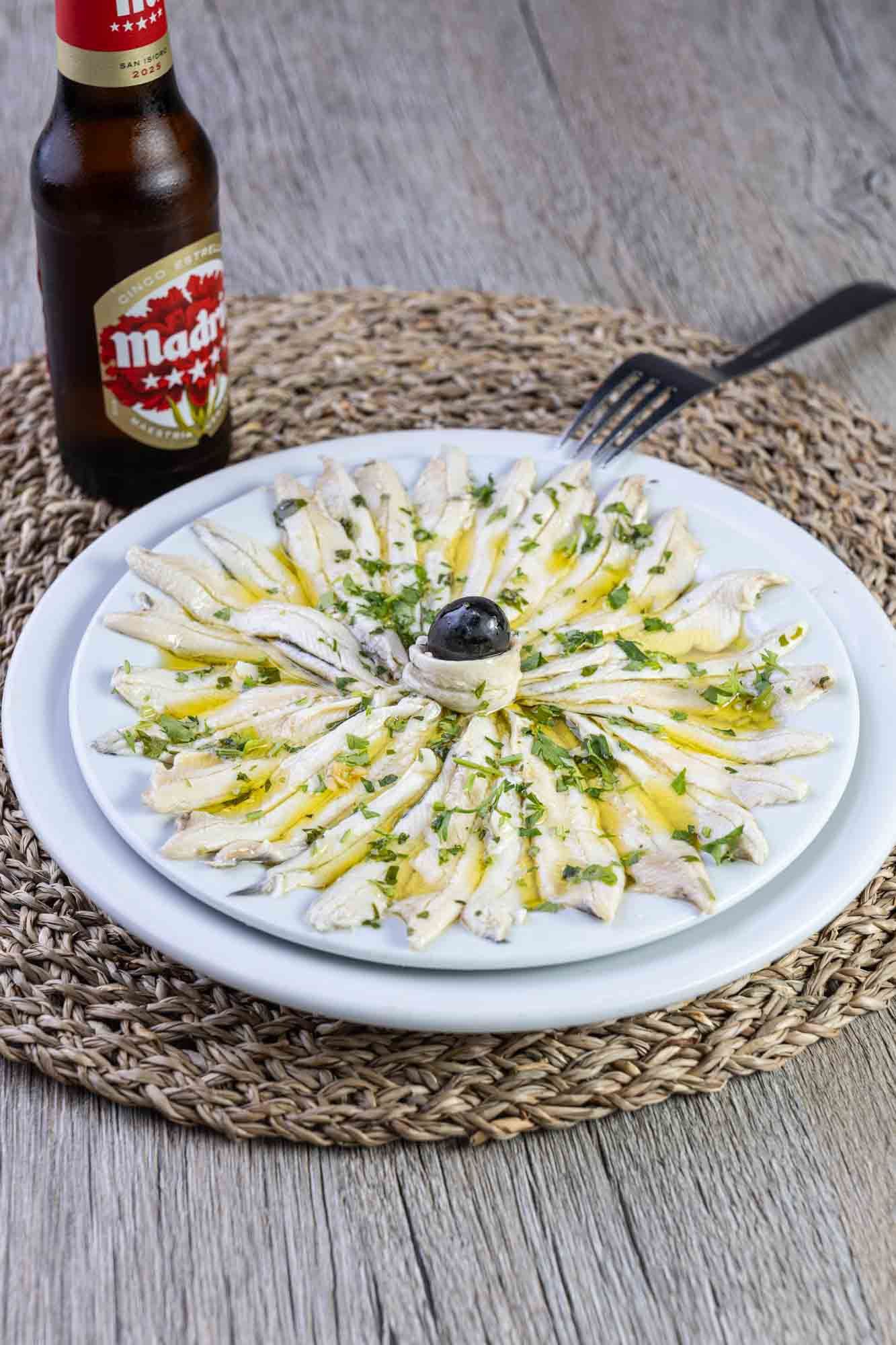 Un plato de comida con una botella de cerveza al fondo.
