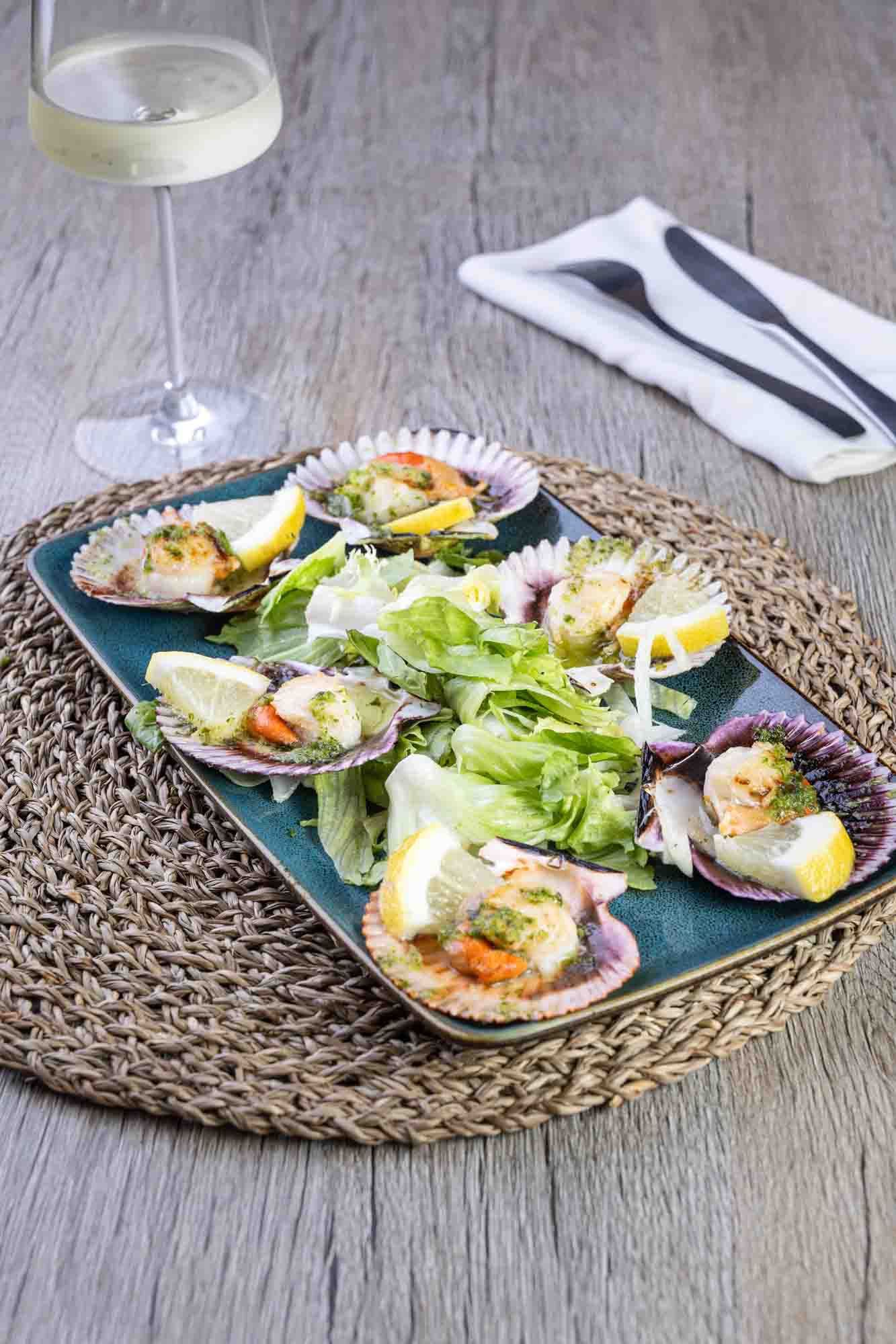 Un plato de comida con una copa de vino en una mesa.