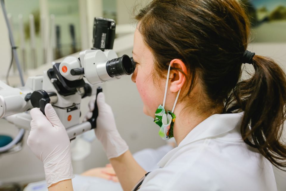 Frau am Mikroskop, Zahnarztpraxis Dr. Krausert