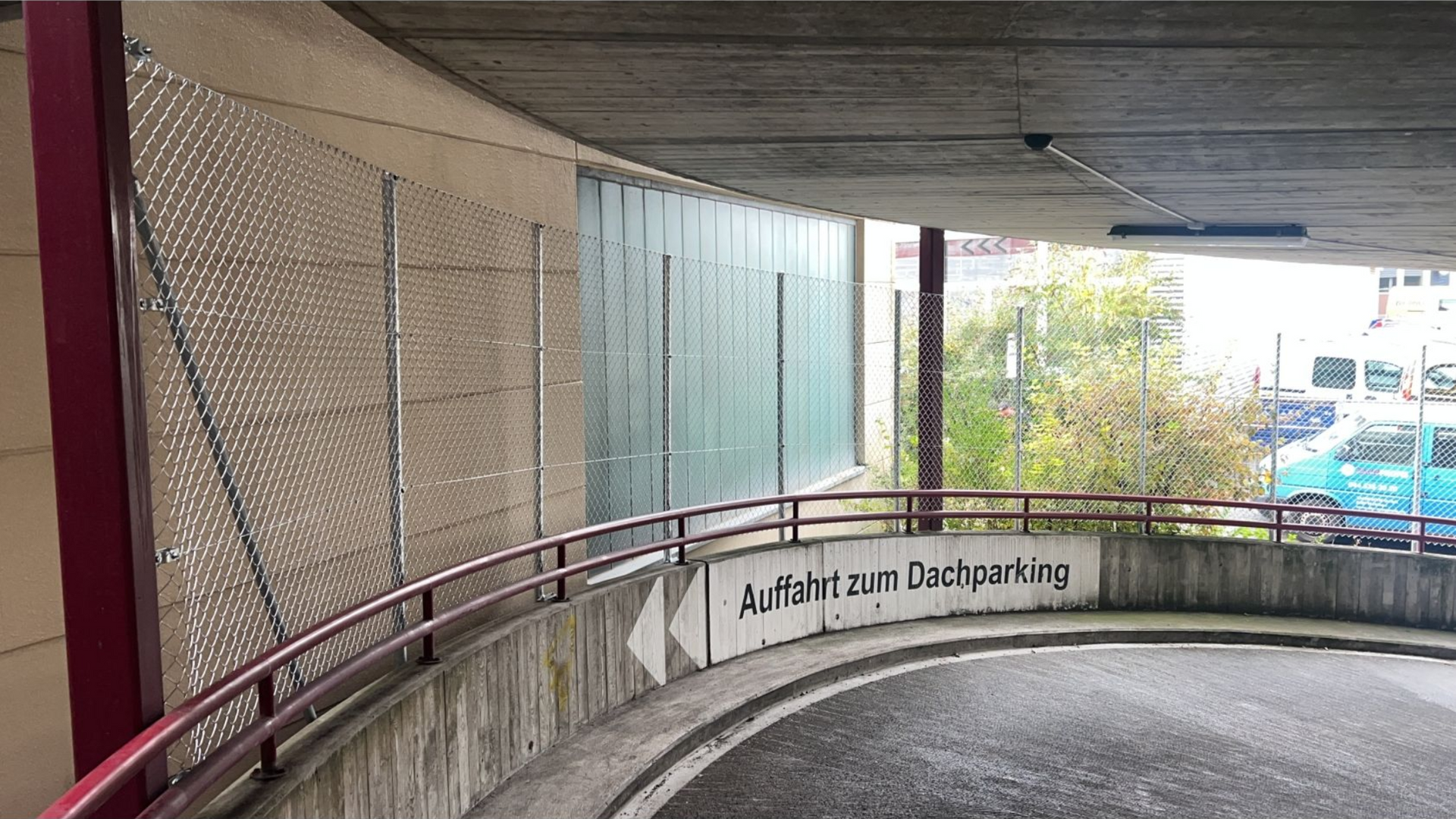 Curving parking garage entrance with a sign: