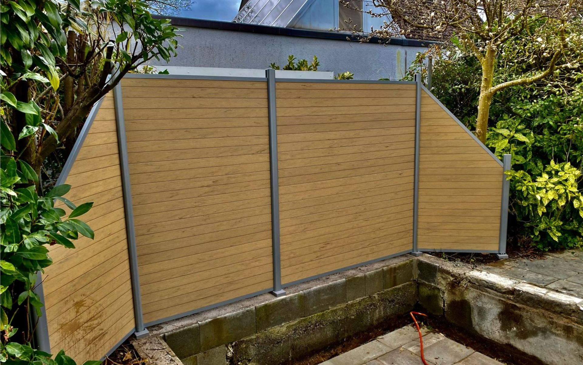 Beiger horizontaler Lattenzaun mit grauen Pfosten in einer Gartenumgebung.