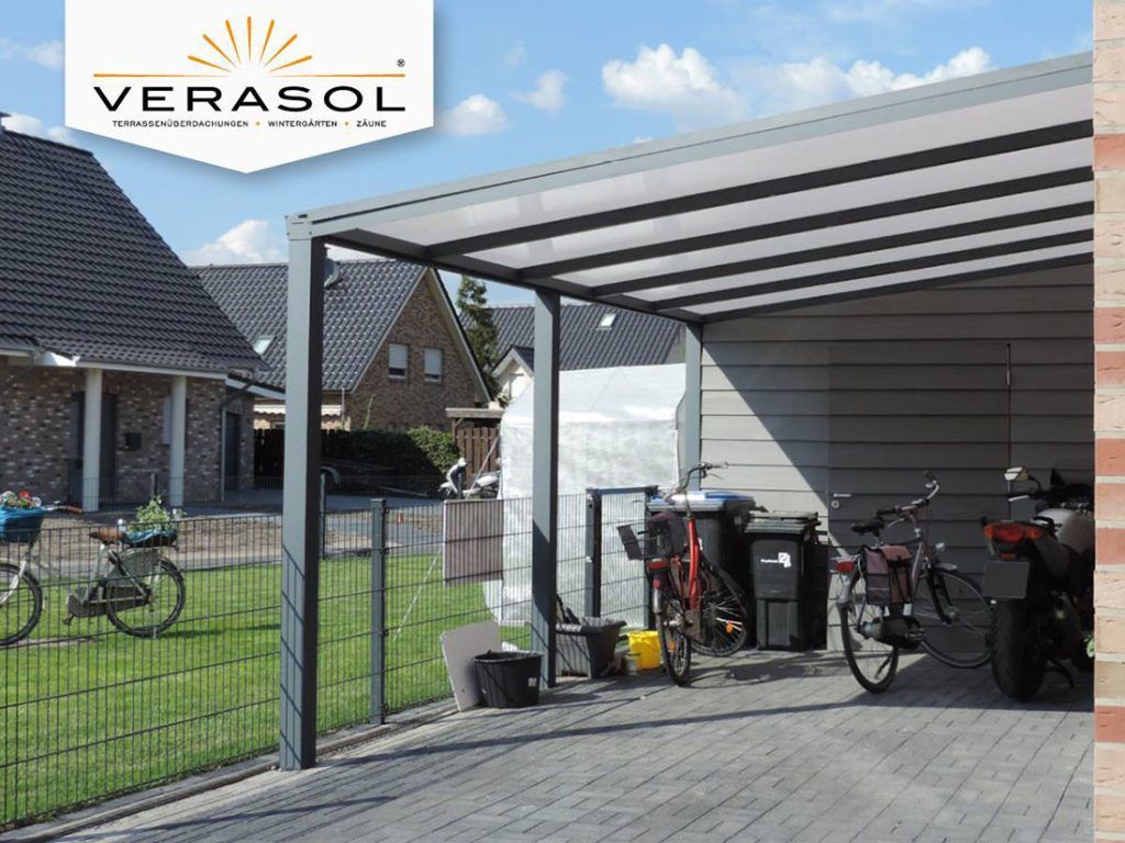 Terrasse couverte avec vélos et rangements à côté d'une maison et d'une cour clôturée