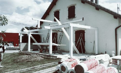Maison blanche endommagée, porche effondré et débris éparpillés après une tempête ou un effondrement de structure