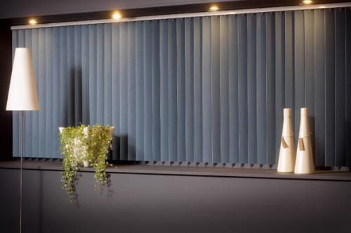 Intérieur moderne avec panneaux muraux verticaux bleus, une lampe suspendue et des plantes décoratives et des vases sur une étagère