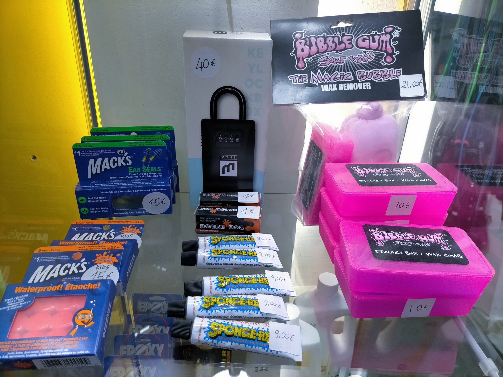 Una vitrina llena de una variedad de productos, incluidos chicles Mack's y un candado.