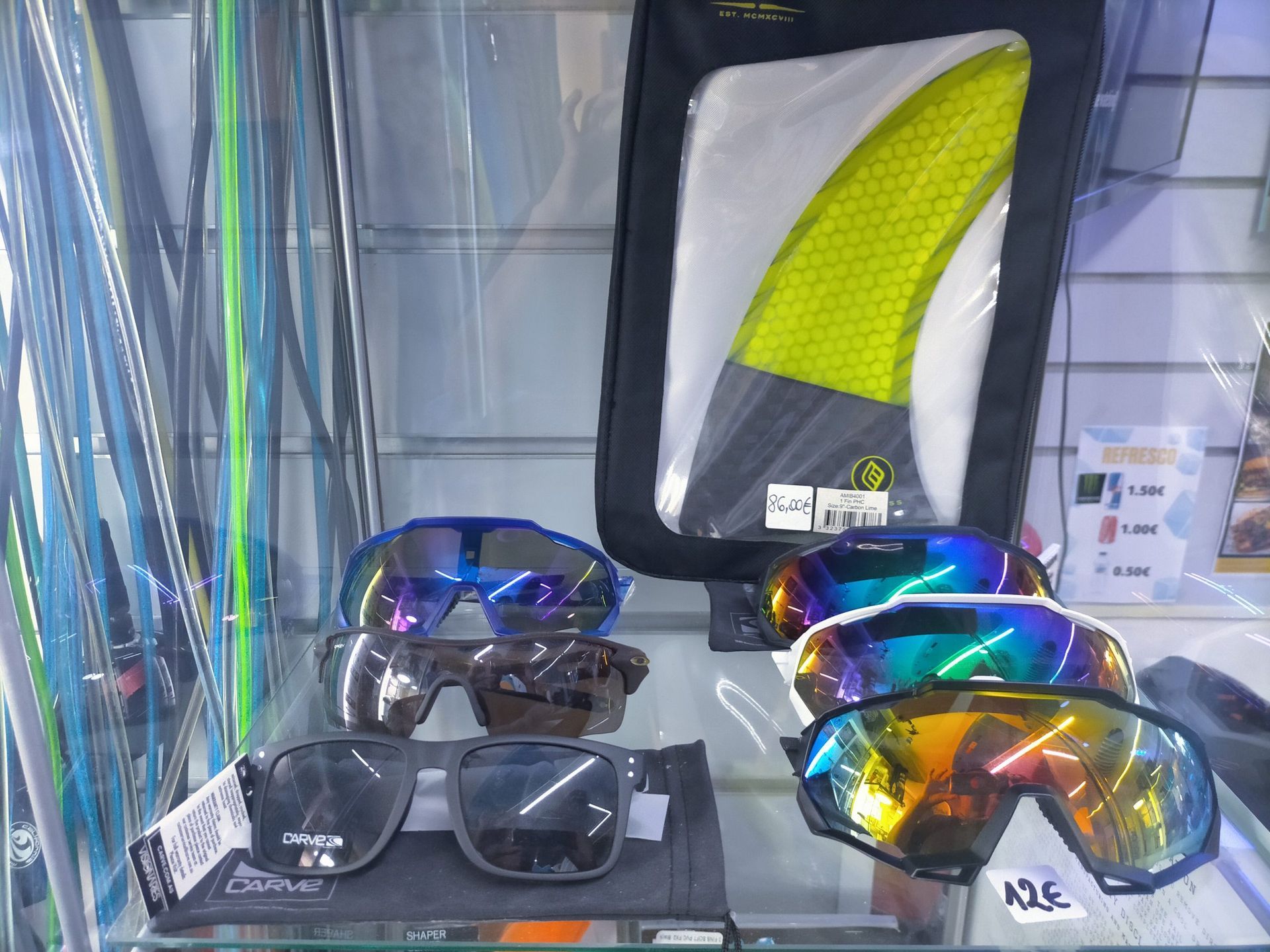 Gafas de sol y una aleta de tabla de surf en exhibición en una tienda