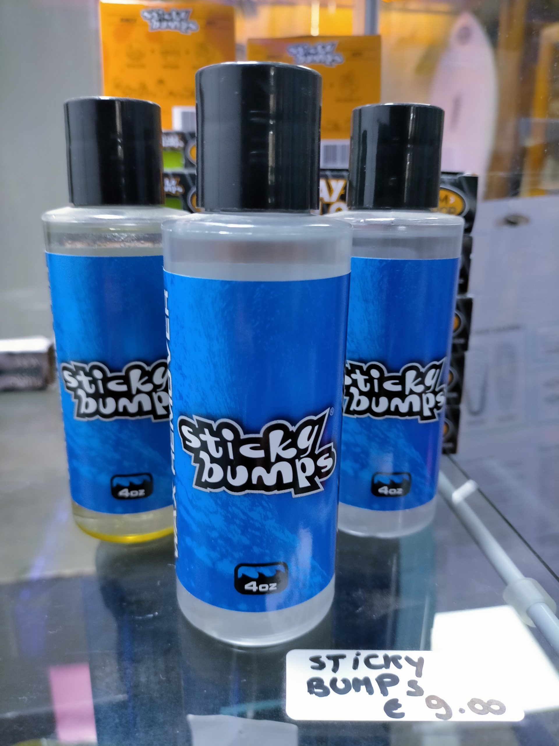 Tres botellas de bultos pegajosos se encuentran en un estante de vidrio