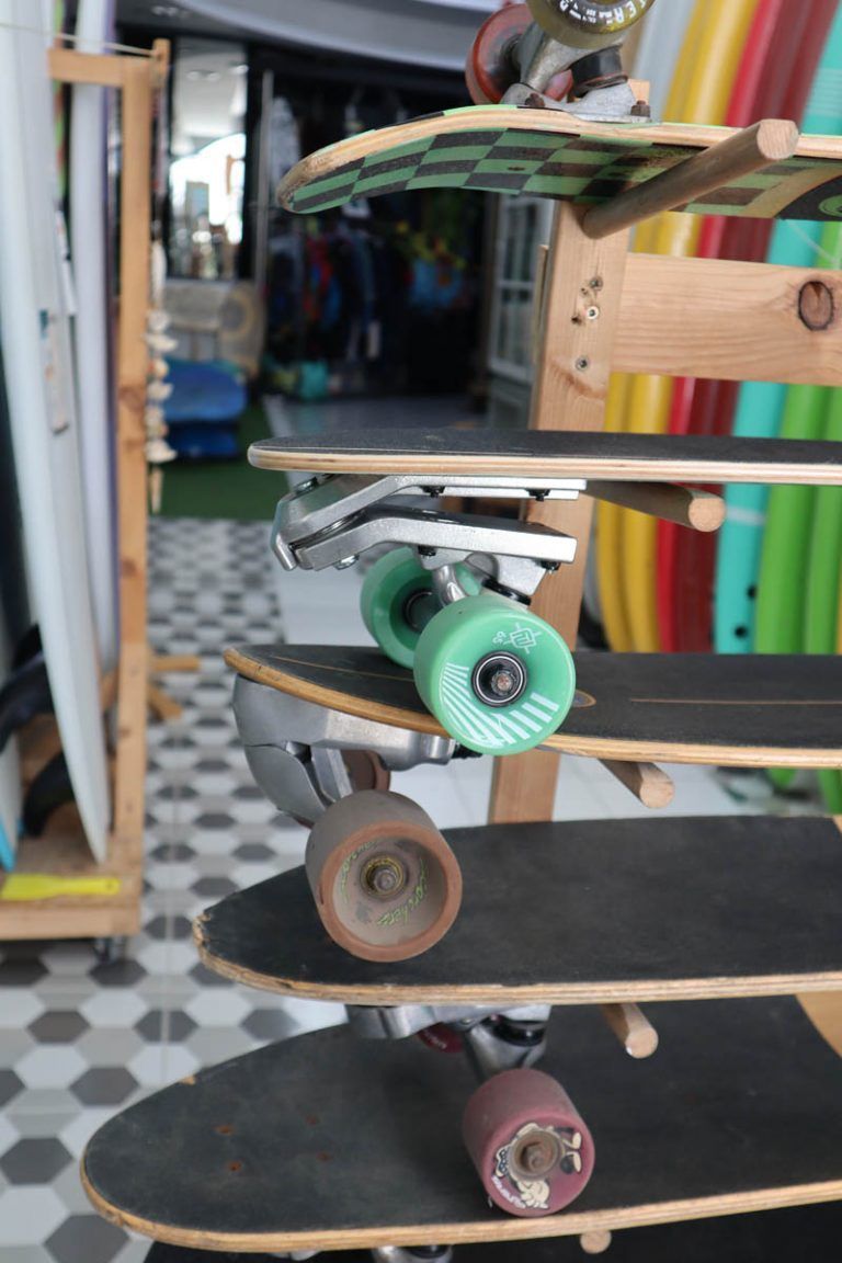 Un montón de patinetas están apiladas una encima de otra en un estante