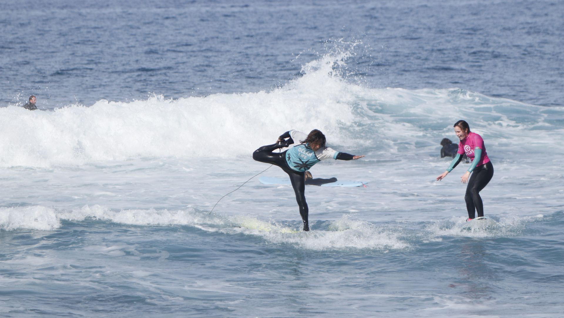 Tres personas están montando olas en tablas de surf en el océano.