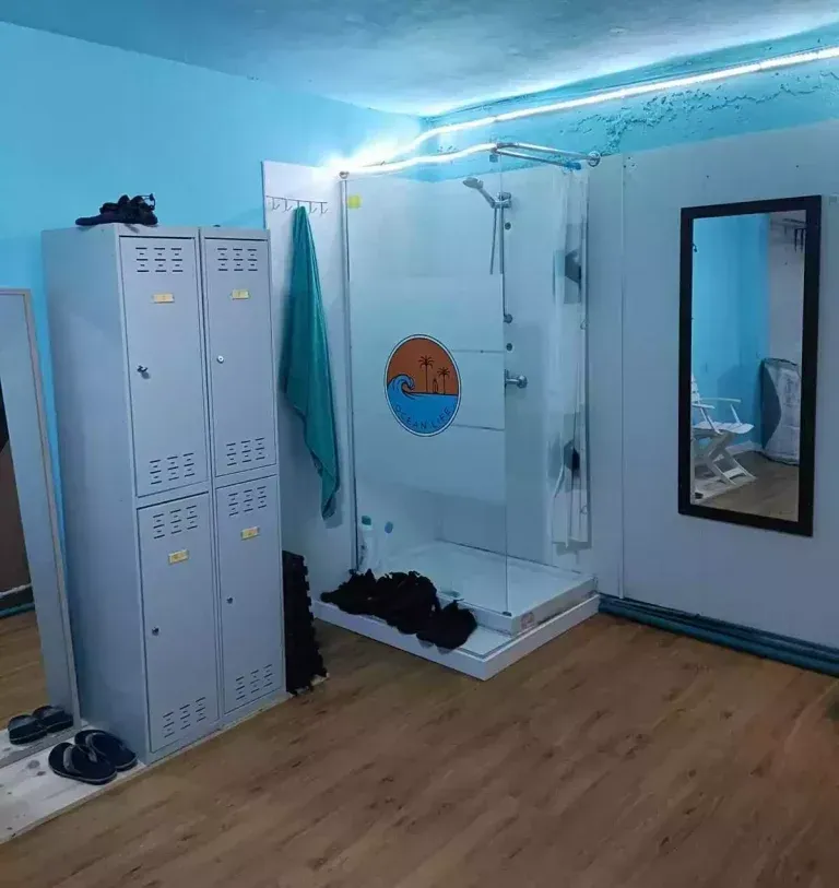 Un vestuario con ducha y espejo.