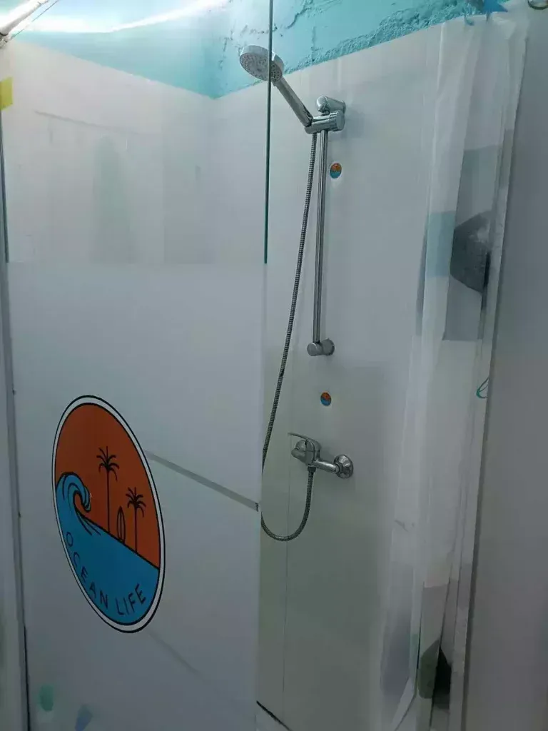 Una cabina de ducha con puerta de cristal transparente y cabezal de ducha.