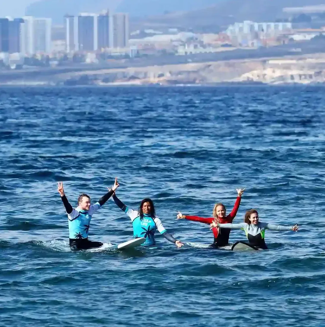 Un grupo de personas están surfeando olas en tablas de surf en el océano.