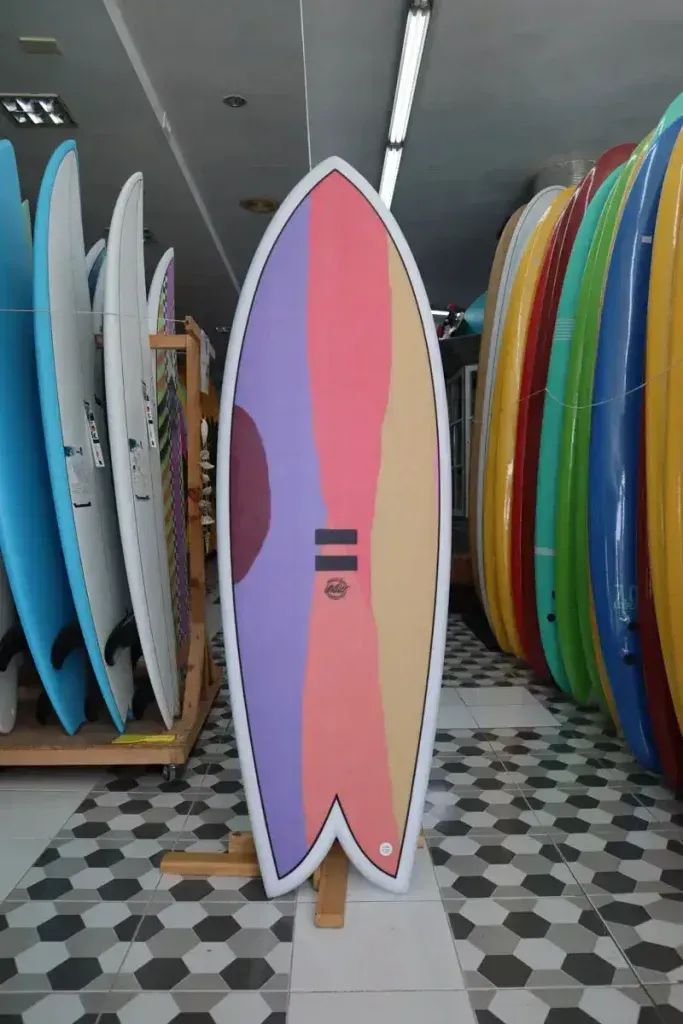 Una tabla de surf colorida está en exhibición en una tienda.
