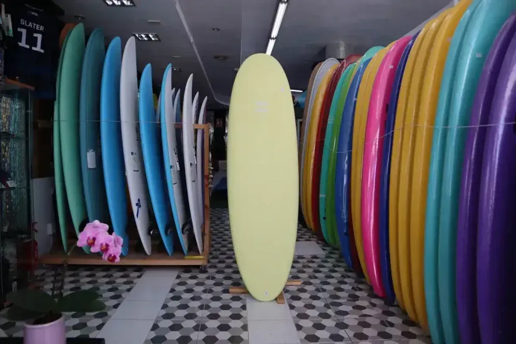 Un montón de tablas de surf están alineadas en una tienda.