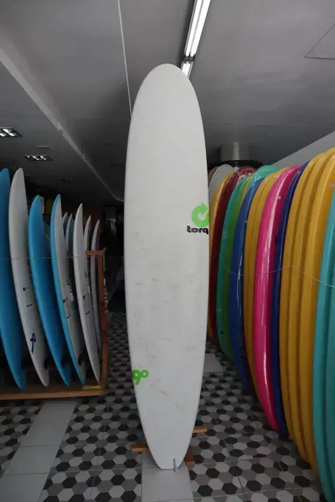 Un montón de tablas de surf están alineadas en una habitación.